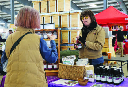 A person stands with their back to the camera and faces a vendor